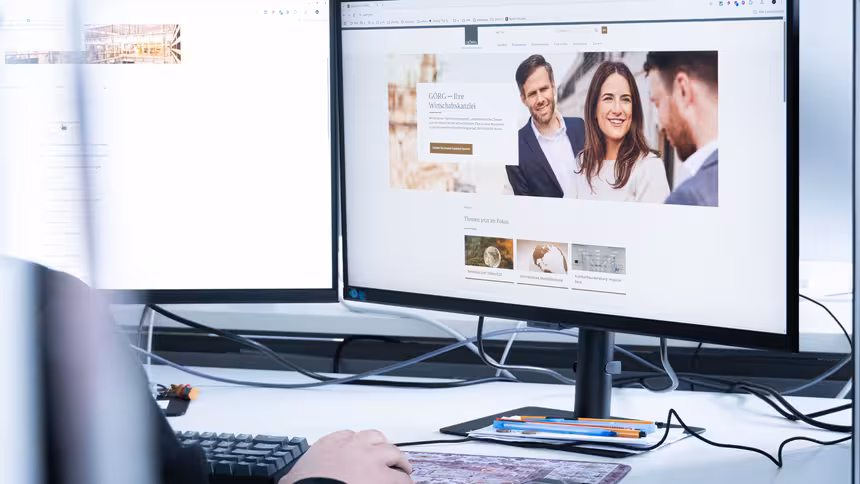Eine Person sitzt vor einem Monitor, der die Website der Kanzlei GÖRG zeigt.