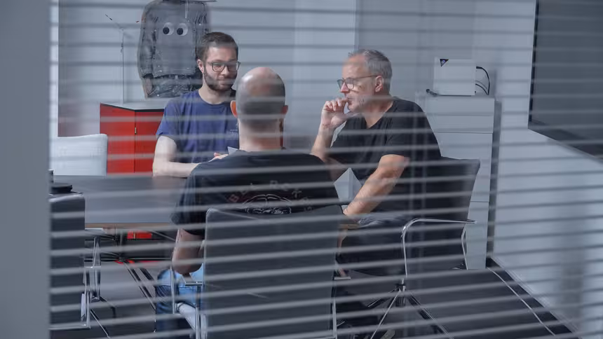 Mehrere Personen sitzen an einem Besprechungstisch