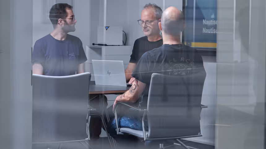 Mehrere Personen sitzen an einem Besprechungstisch
